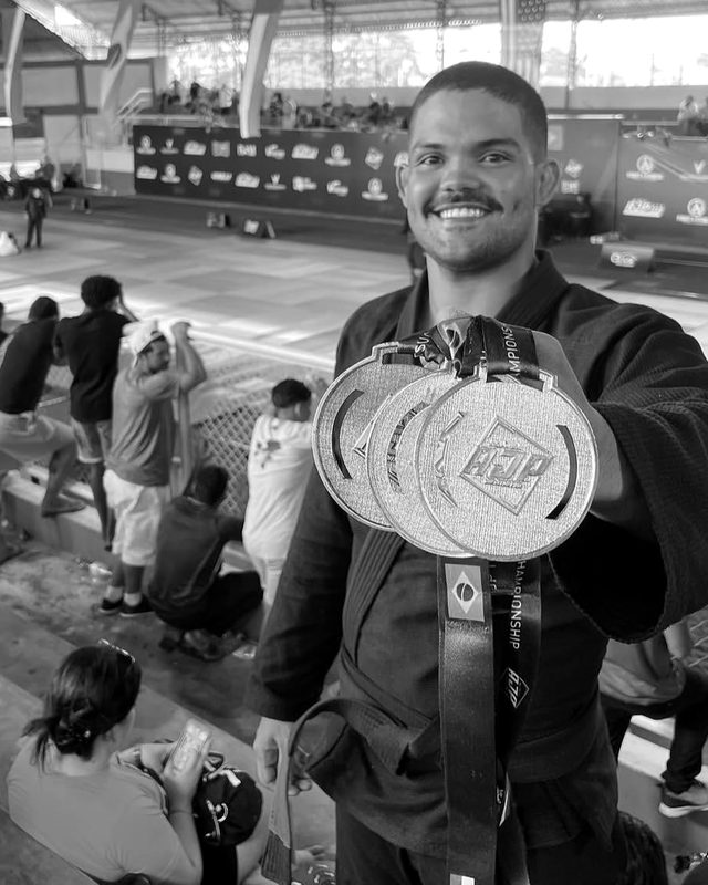 Atleta com o cinturão de campeão dentro do cage
